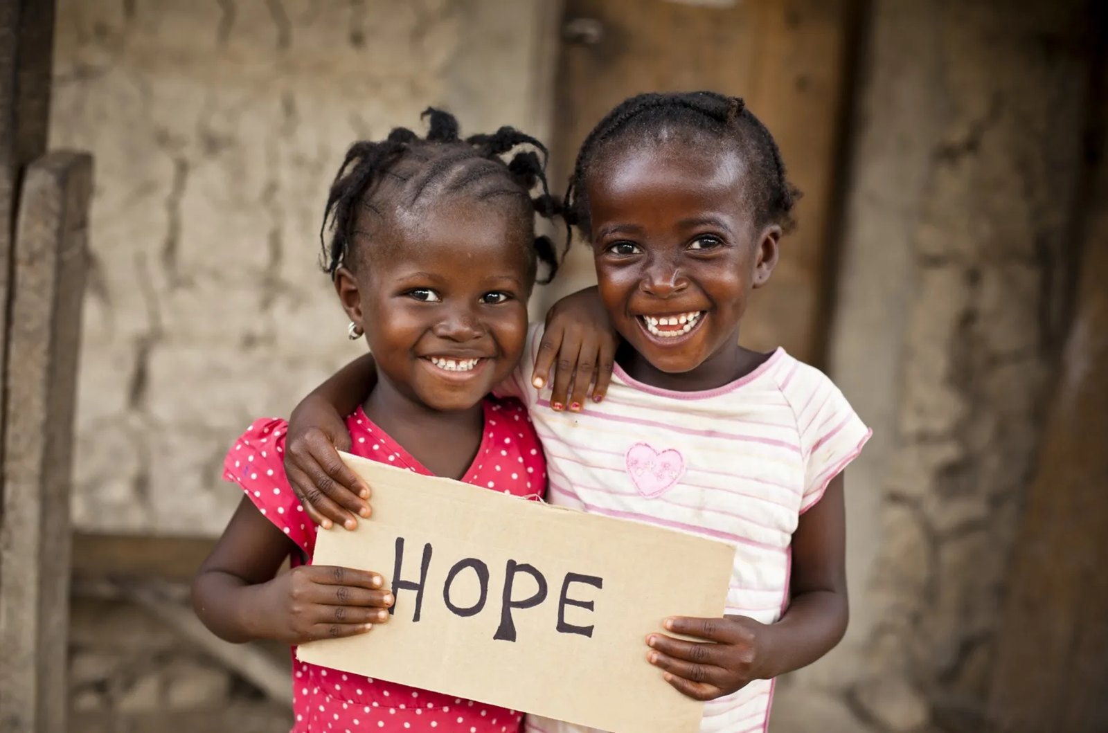 Two girls, one holding a HOPE sign